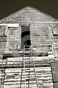 Black and White) Bent ladder reaches to a granary door