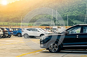 Black, white and blue new car parked on concrete parking area at factory near the mountain. Car dealership concept. Car stock