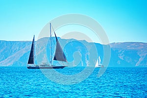 Black and white boat sailing in the open blue sea in Greece