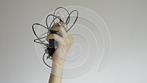 Black and white cables in a woman`s hand on  background