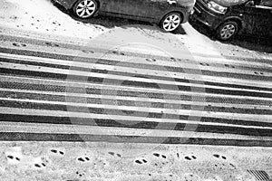 Black and white car treads and footprints in snow