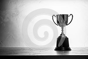 Black and white champion golden trophy placed on wooden table