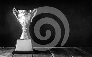 black and white champion trophy on wood table with blackboard co photo