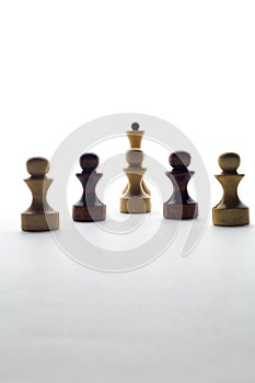 Black and white chess pawns and queen on a white background photo