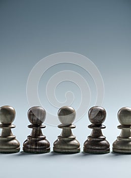 Chess pawns standing together in line