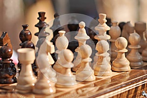 Black and white chess pieces on a chessboard, closeup. Set of chess figures on the playing board