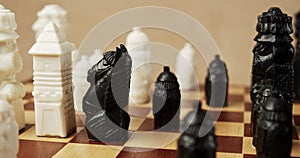 Black and white chess pieces on a wooden chessboard