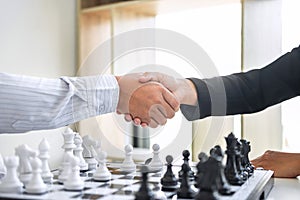 Black and White chess with player, Businessman and Businesswoman shaking hands after end game of thinking strategy to moving chess