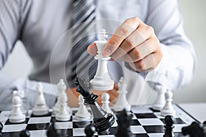 Black and White chess with player, Hands of businessman thinking to moving chess figure in competition and planning strategy to