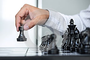 Black and White chess with player, Hands of businessman thinking to moving chess figure in competition and planning strategy to