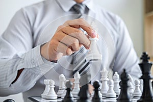 Black and White chess with player, Hands of businessman thinking to moving chess figure in competition and planning strategy to