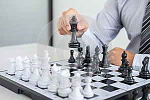 Black and White chess with player, Hands of businessman thinking to moving chess figure in competition and planning strategy to