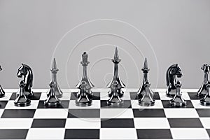 Black and white chessboard with black figures isolated on grey.