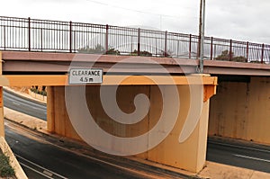 a black and white Clearance 4.5 m warning information sign for high vehicles on a traffic under pass