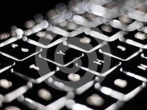 Black and white close-up on illuminated keys of computer keyboard
