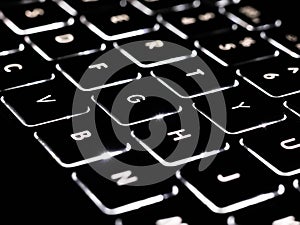 Black and white close-up on illuminated keys of computer keyboard