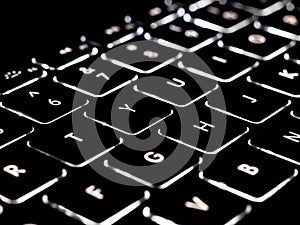 Black and white close-up on illuminated keys of computer keyboard