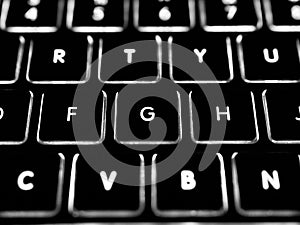 Black and white close-up on illuminated keys of computer keyboard