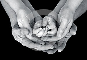 Black and white close up image of a family's supporting hands