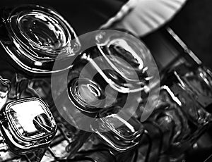 Black and white close-up image of whiskey Old Fashioned or Rocks glasses along with shot or shooter glasses on a dish drainer in t