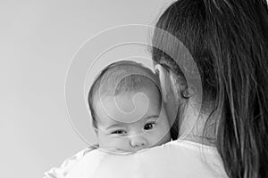 black and white close up portrait face of mom with chubby newborn baby copy space. Young cute caucasian woman holding
