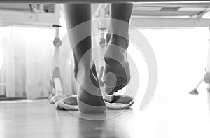 Black and white closeup photo of from under the bed on woman wearing slippers