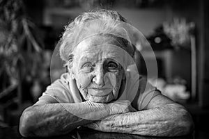 Black-and-white closeup portrait of an elderly positiv woman.