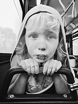 Black and white closeup portrait of funny little girl in bus and making funny silly faces with duck face lips