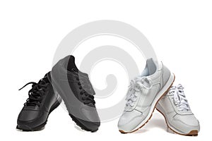 Black And White Concepts. Two Pairs of New Black and White Modern Sport Trainer Shoes  Placed over Over White Background