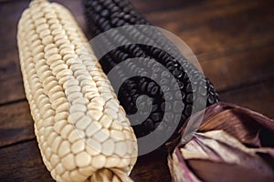 Black and white corn on wooden table, perspective