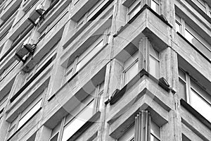 Black and white corner of a building with windows.