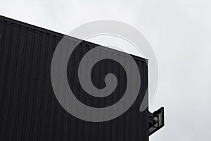 Black and white Corrugated metal sheet texture surface on a building wall with a cloudy sky. Galvanize steel background.