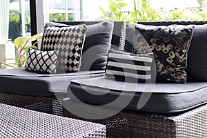 black, white cushion and pillow on wicker chair