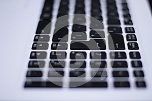 Black and white, defocused computer keyboard with focus on some keys