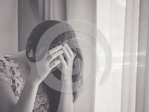 Black and white depressed woman crying while sitting alone