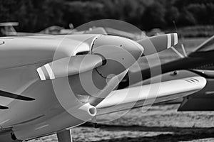 Black and white developed image of the front part of a single engine propeller aircraft.