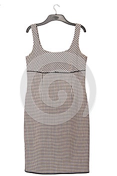 Black and white dress with checkered pattern is on coat-hanger, pinafore dress photo