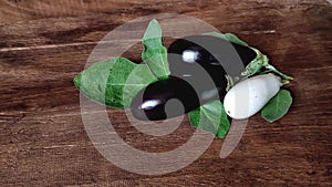 black and white eggplant aubergine with leaves on the table