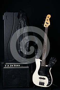 Black and white electric bass guitar with amplifier, jack cable