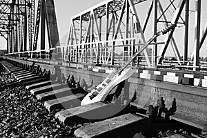 Black and white electric guitar on the railroad tracks and stone