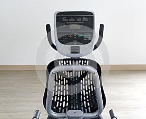 Black and white electric stationary recumbent bike in a gym for cardio, toning legs, burning calories and losing weight