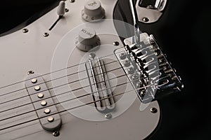 Black and white electronic guitar close up view.