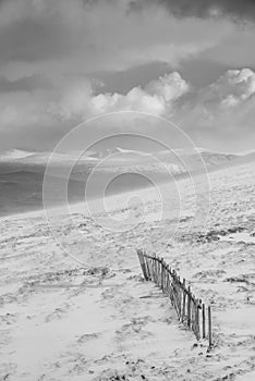 Black and white epic Winter landscape image from mountain top looking across to Rannoch Moor