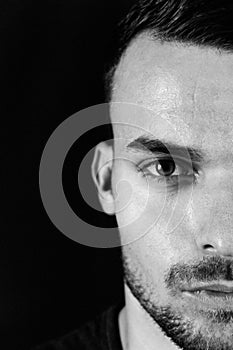 Black and white fashion dark portrait of young man with glasses on black background. Portrait of intelligent man. Photo port