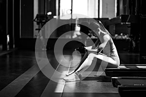 black and white Fitness young woman sitting in the gym and resting after doing a workout