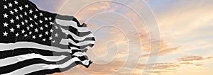 black and white flags of USA waving in the wind on flagpoles against sky with sunset clouds on sunny day. Symbolizing mourning. 3d