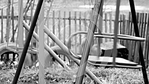 Black and white footage shot of deserted old abandoned ghetto playground swings. video stylized as old movie