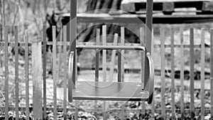 Black and white footage shot of deserted old abandoned ghetto playground swings. video stylized as old movie