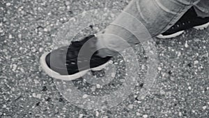 Black and white footage of women`s feet in sneakers. Girl walking around the city.