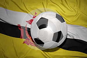 Black and white football ball on the national flag of brunei